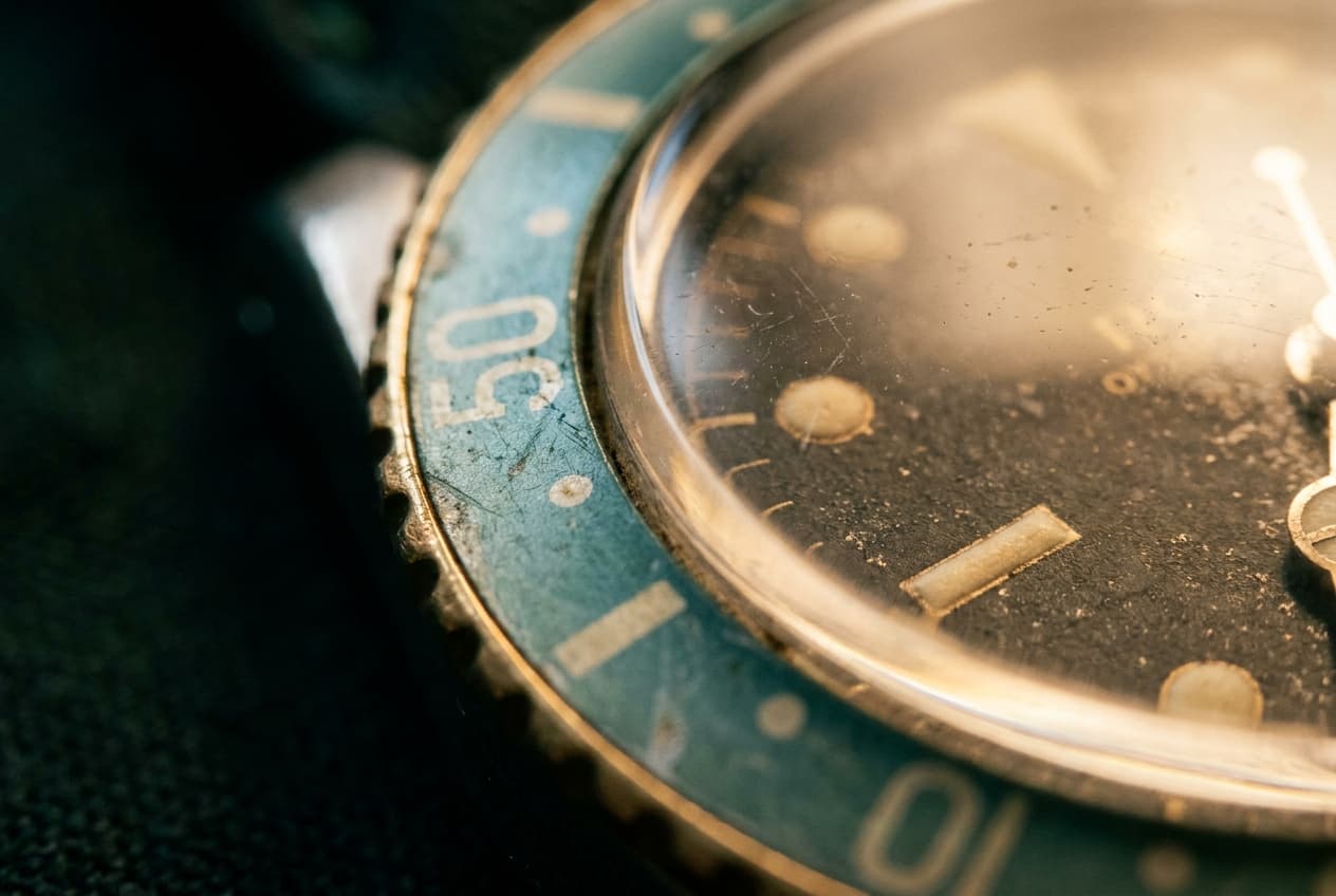 Vintage-Zifferblatt mit warmer Patina und teal-grüner Lünette
